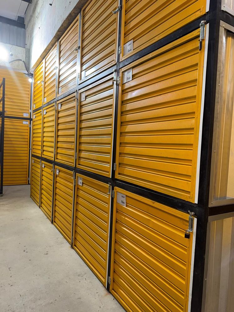 Fileira de boxes individuais organizados, com portas amarelas fechadas
