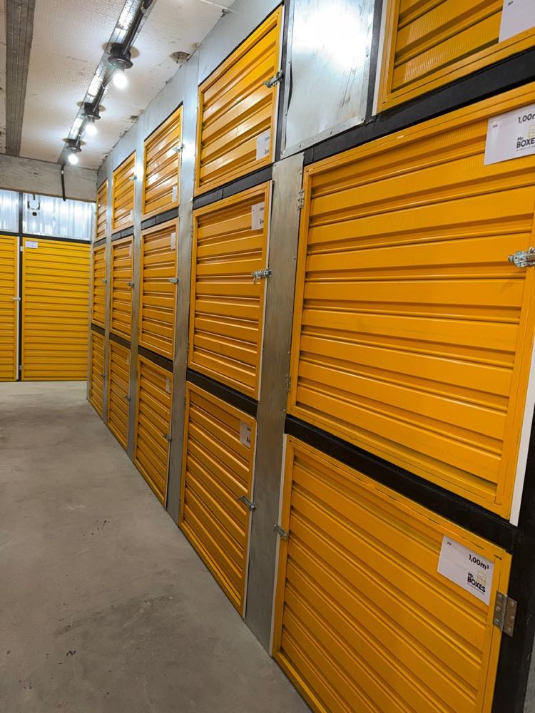 Boxes individuais empilhados em dois níveis, com portas amarelas identificadas